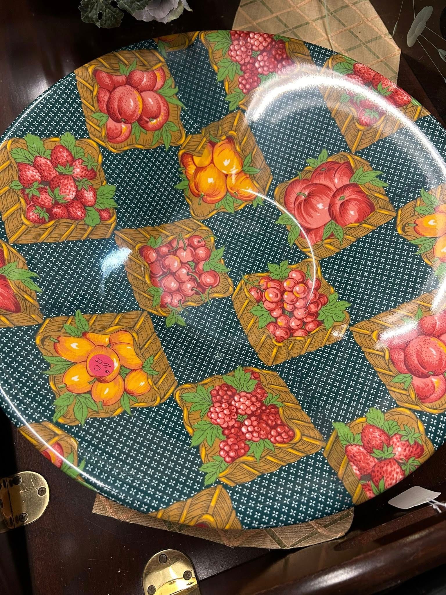 Colorful round tray with fruit-patterned patchwork and white polka dots on a dark table