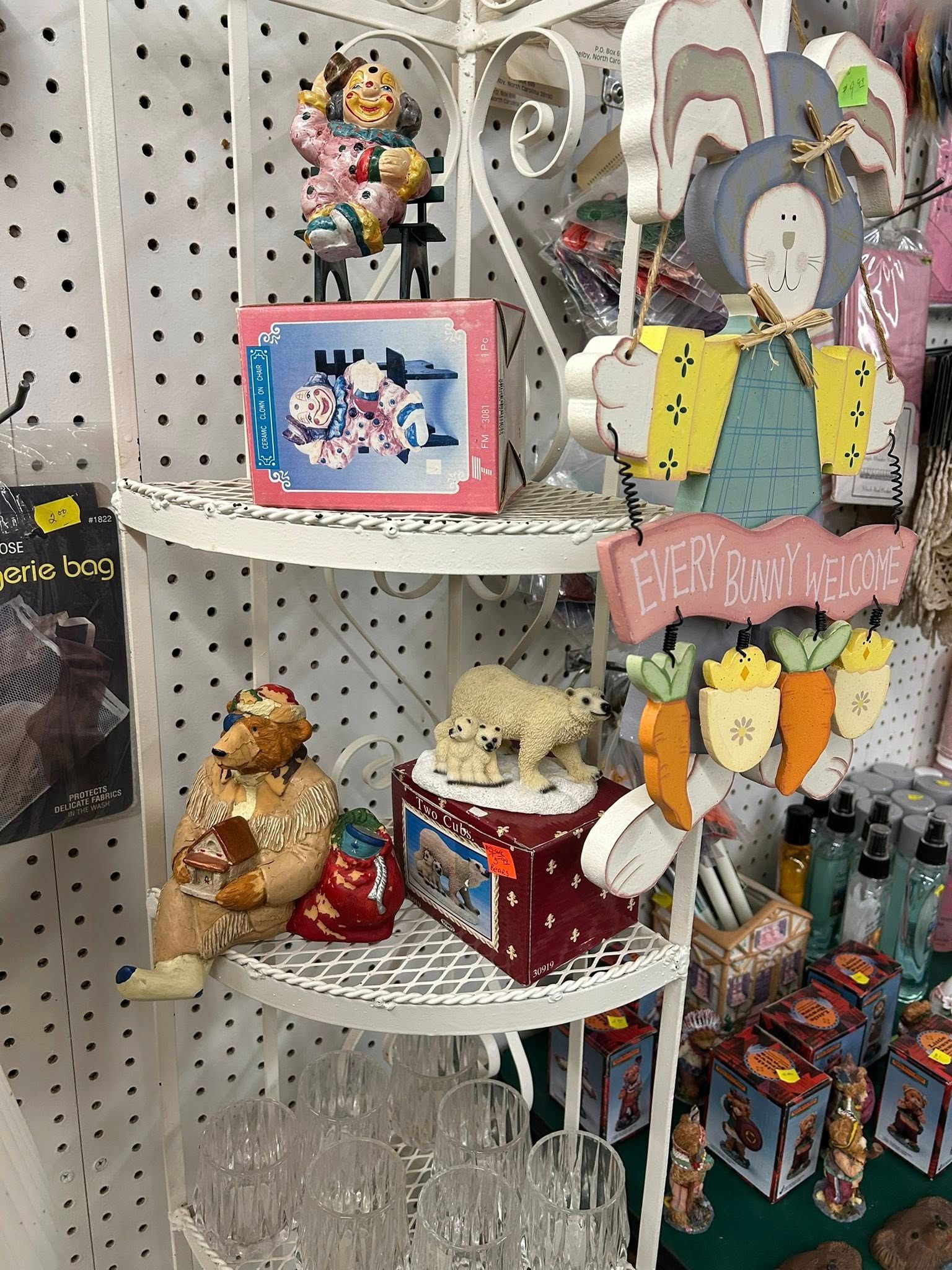 Pastel gift display on white shelves with plush toys, ornaments, and hanging glassware