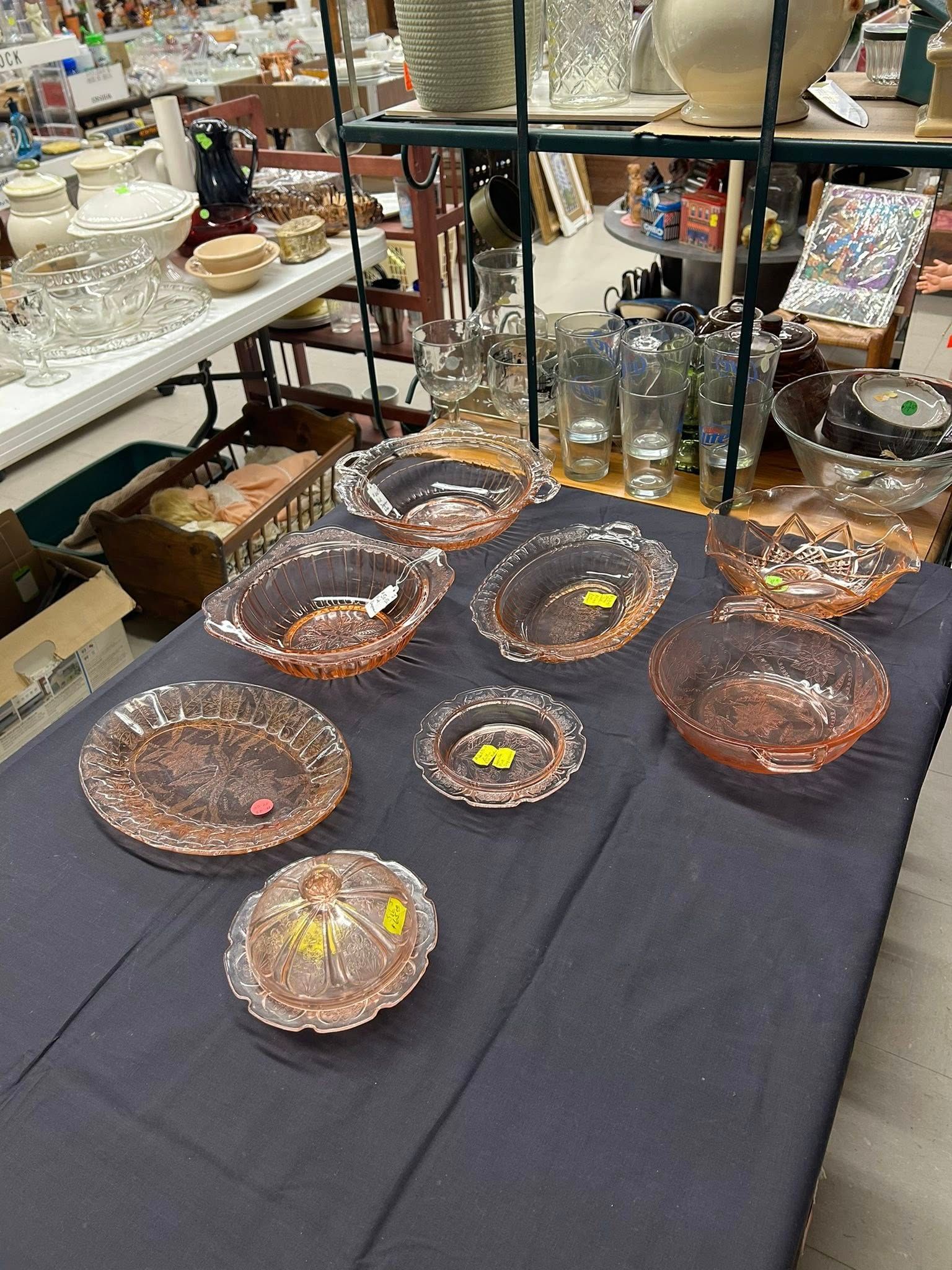 Assorted handmade glass bowls displayed on a black tablecloth at a craft market booth