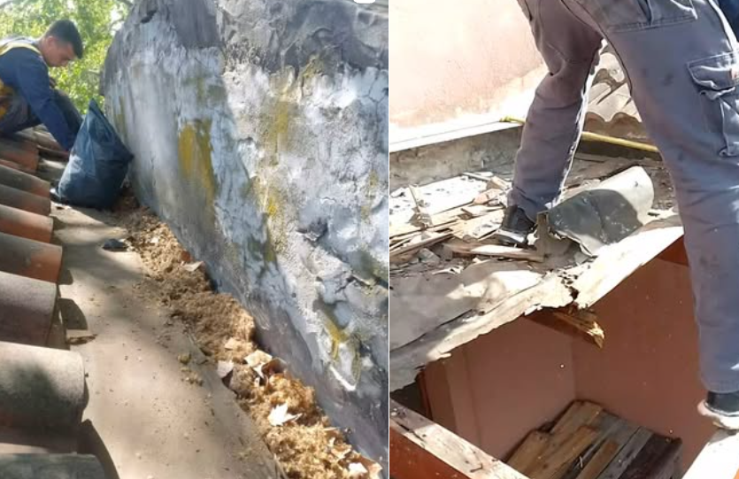 Un trabajador reparando un tejado da&ntilde;ado junto a una pared, con escombros amontonados a lo largo del borde.