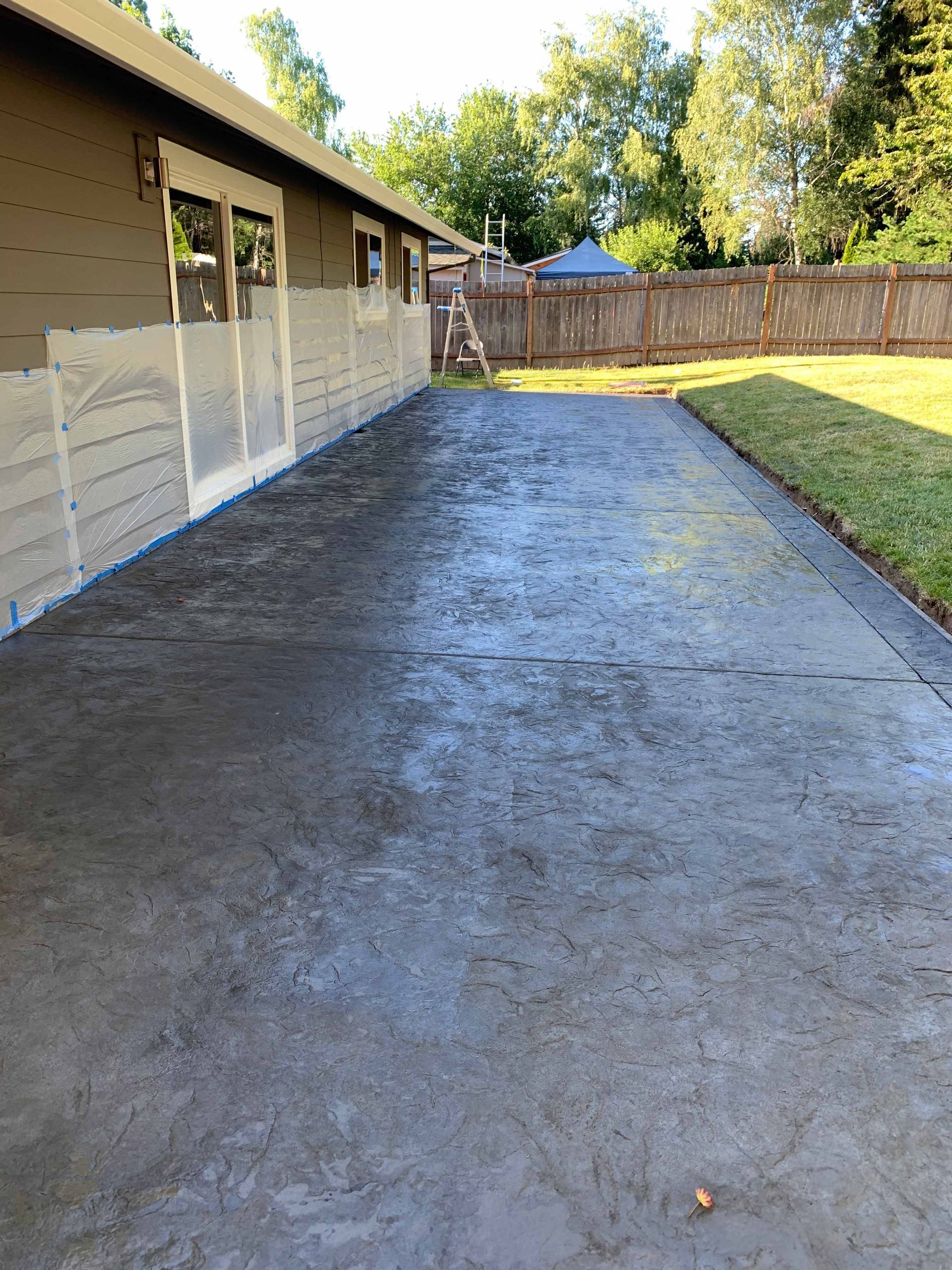 A concrete driveway in front of a house with a fence in Portland OR