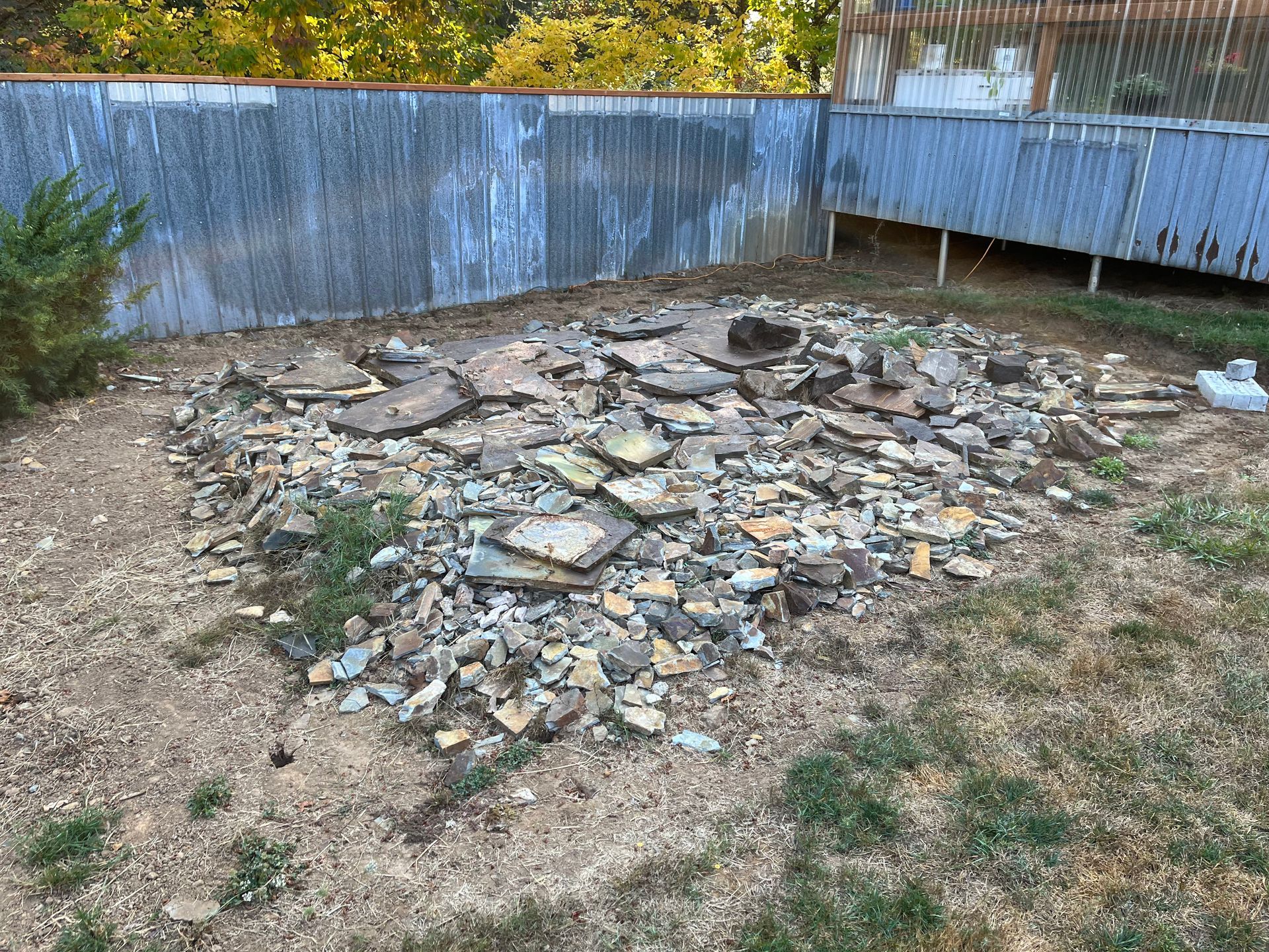 a pile of rocks in a yard next to a fence in Portland OR