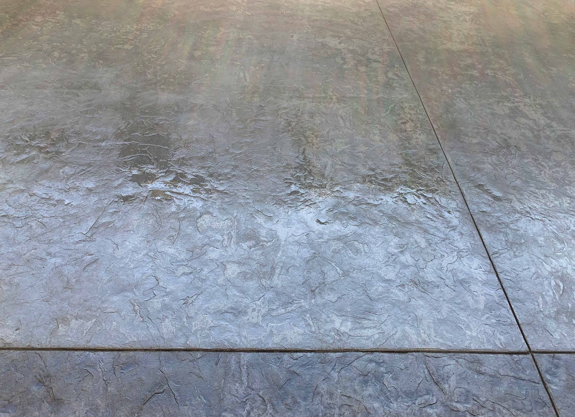 A close up of a concrete floor with a lot of stains on it in Portland OR