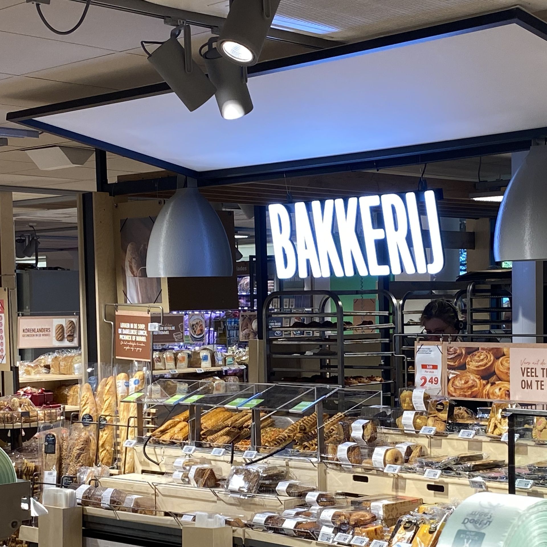 Bakkerijtoonbank met gebak en brood onder een opvallend 