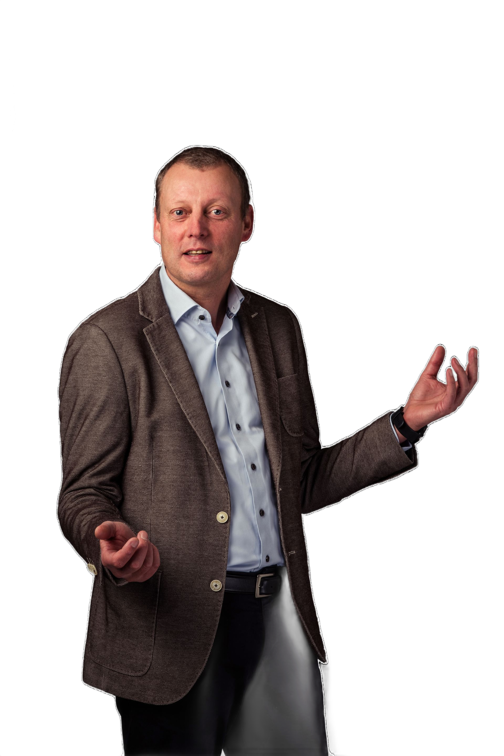 Een man staat tegen een witte achtergrond en gebaart met beide handen. Hij draagt ​​een jas met patroon en een licht overhemd.