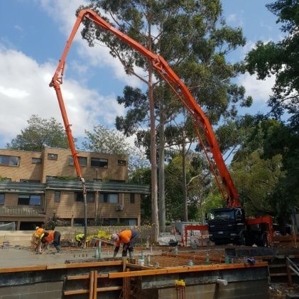 A concrete pump is being used to pour concrete on a construction site