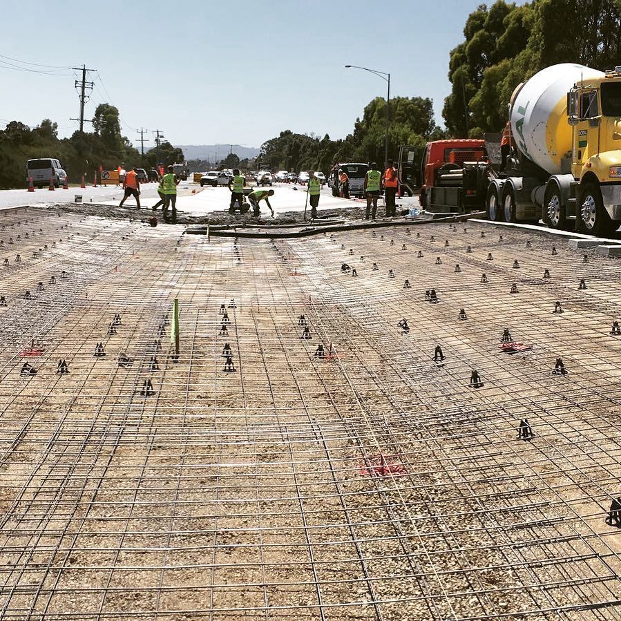 A group of construction workers are working on a road.