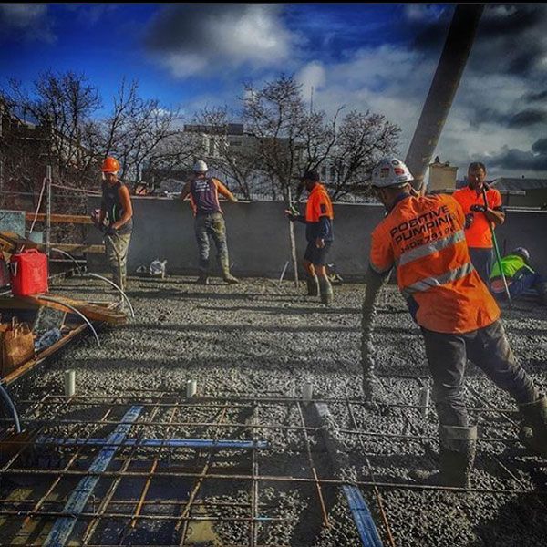 A group of construction workers are working on a concrete floor