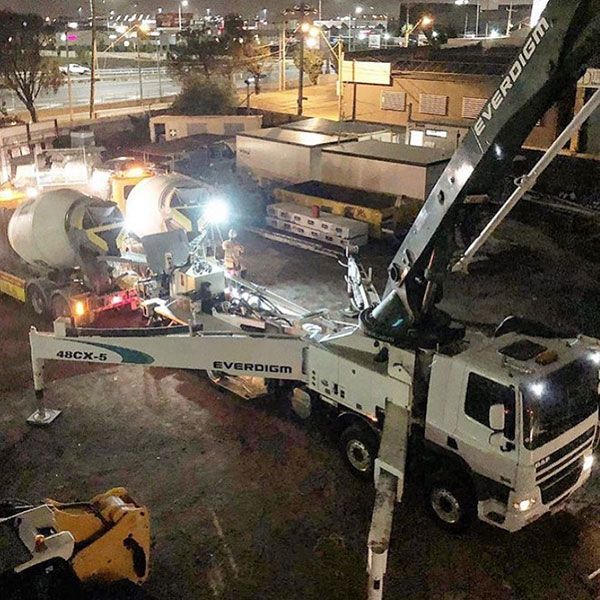 An evergreen concrete pump truck is being used to pump concrete