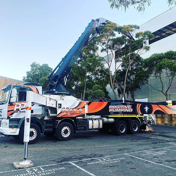 A positive pumping truck is parked in a parking lot