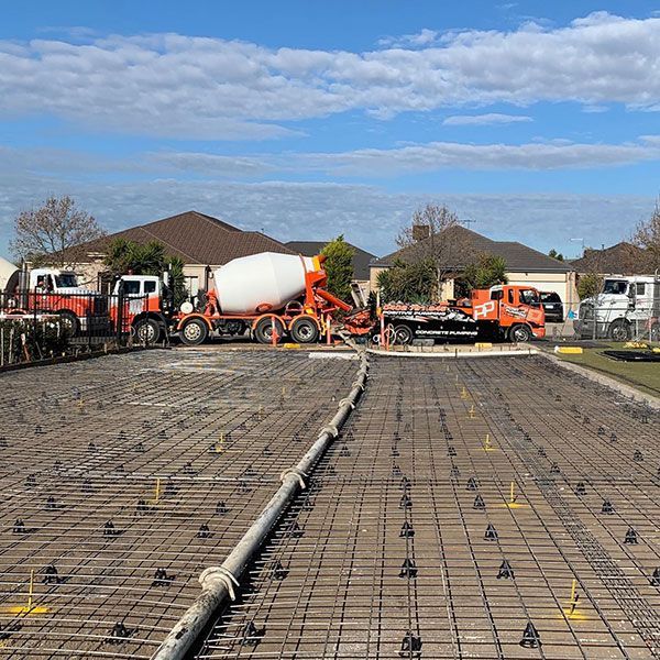 A concrete mixer truck is pouring concrete into a concrete slab.