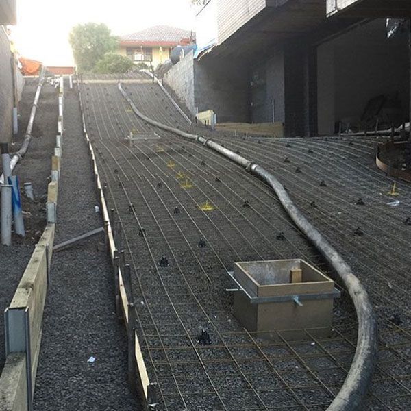 A hose is being used to pump concrete down a ramp