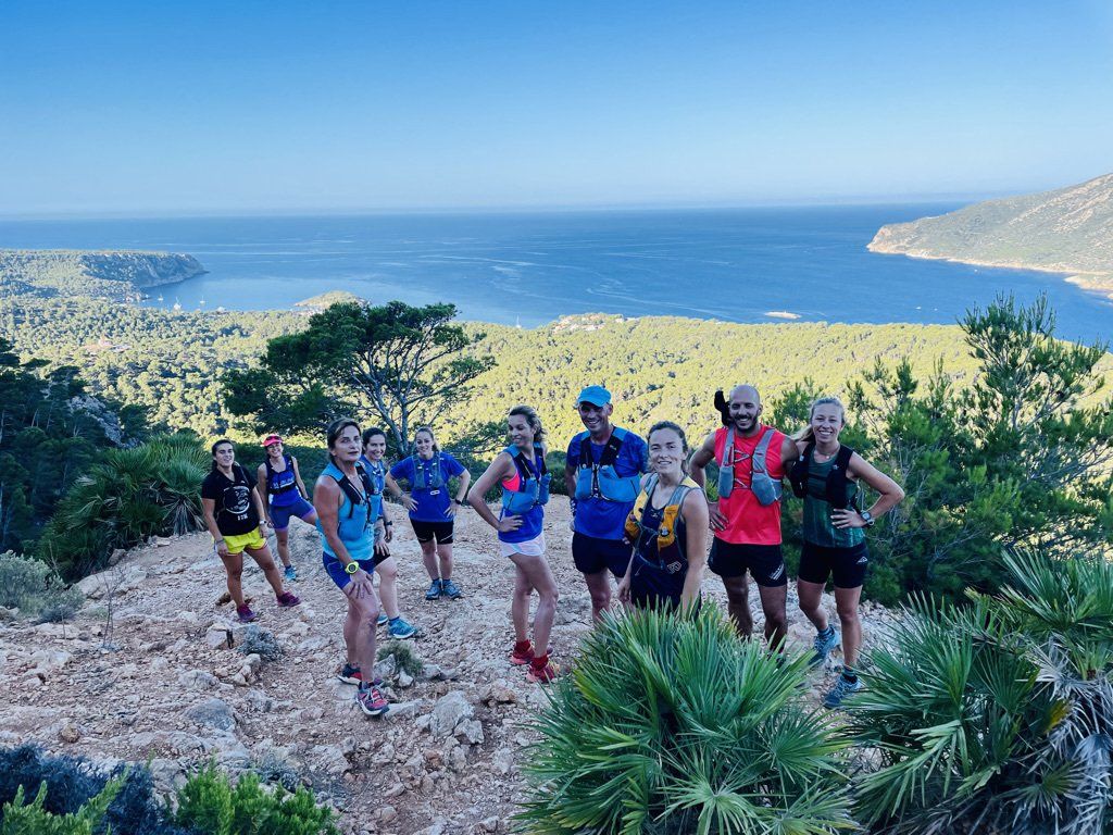 Un grupo de personas posa para una fotografía en la cima de una montaña.