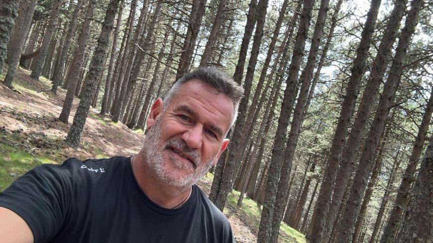 Un hombre con barba se está tomando un selfie en el bosque.