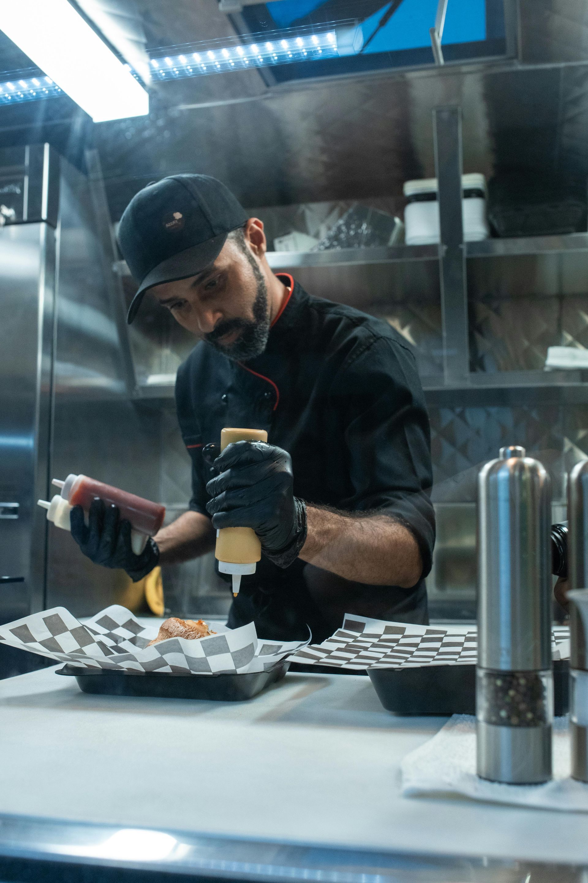 A man in a chef 's uniform is preparing food in a food truck.