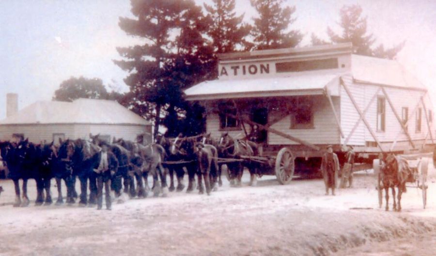 A group of people are standing in front of a building that says station