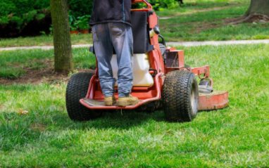Man professionally mowing grass at a commercial building in Cheyenne