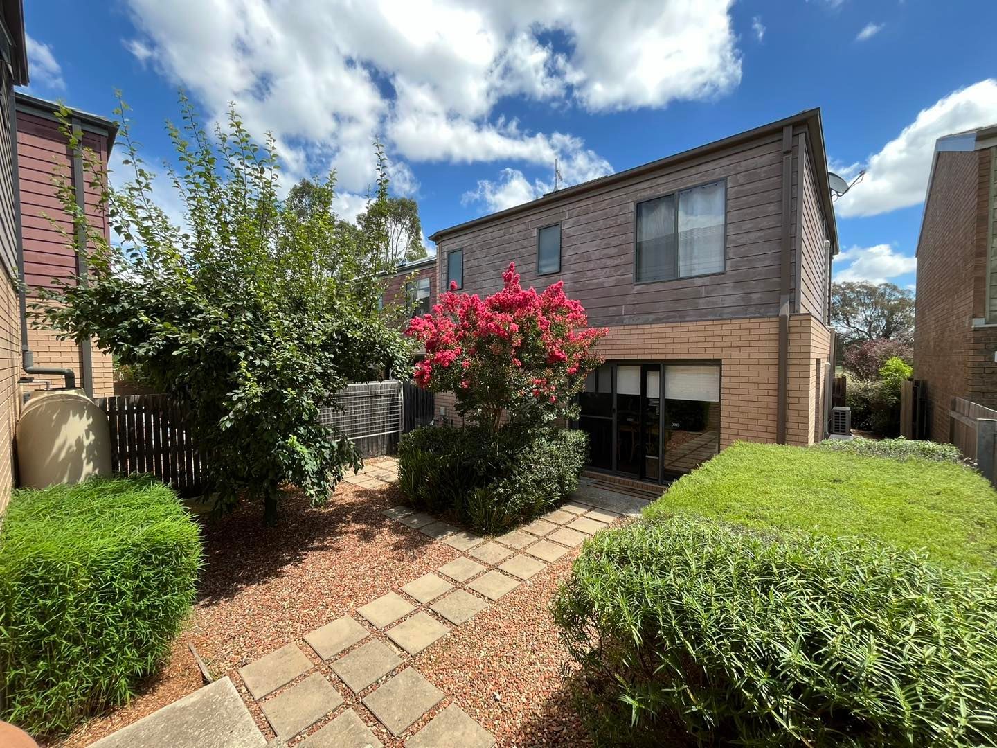 After A Small Pond With Pink Flowers In It Is Surrounded By Rocks And Bricks — Canberra Home and Garden Maintenance in Tuggeranong ACT