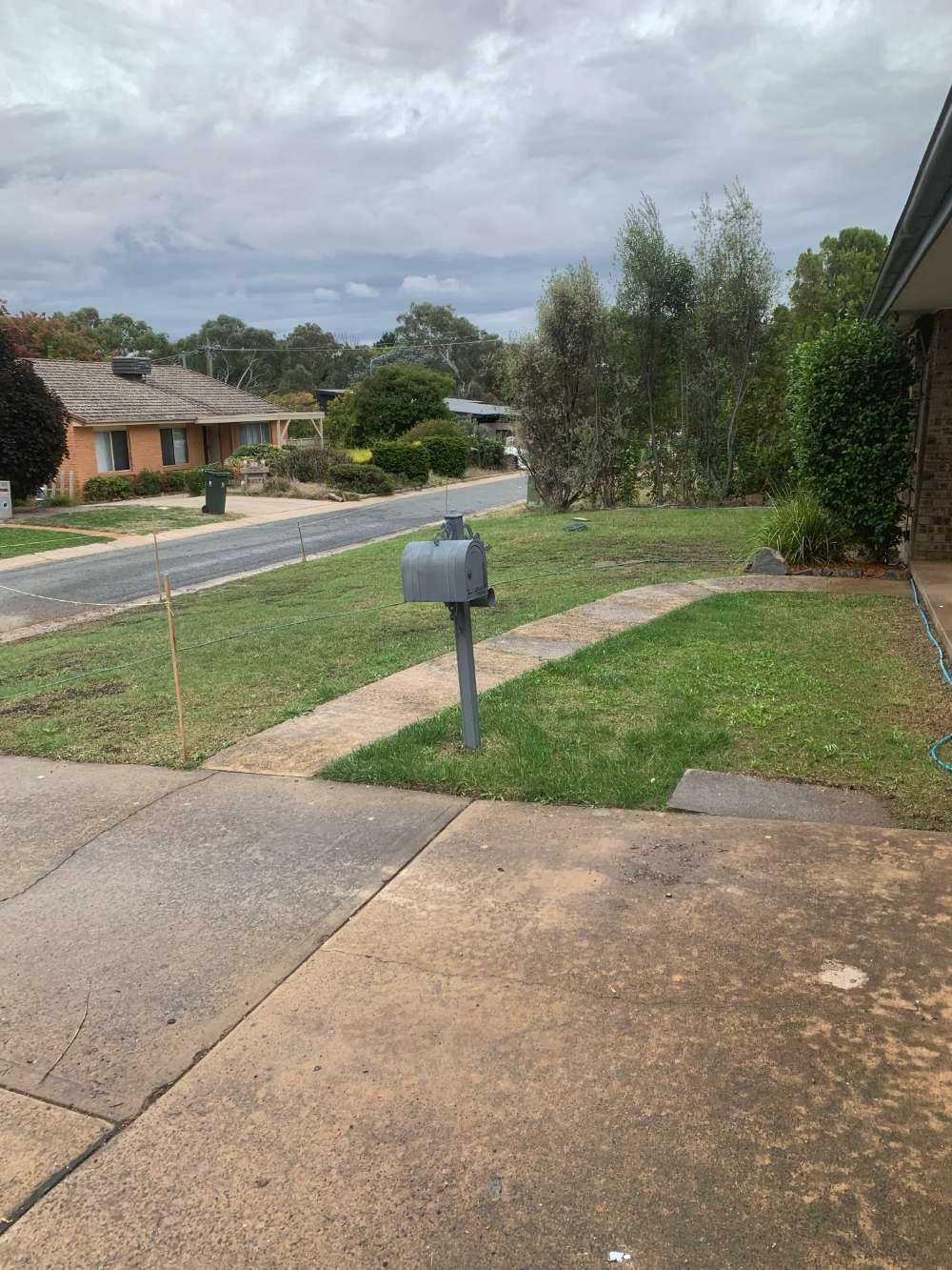 Before A mailbox is sitting on the sidewalk in front of a house — Canberra Home and Garden Maintenance in Tuggeranong ACT