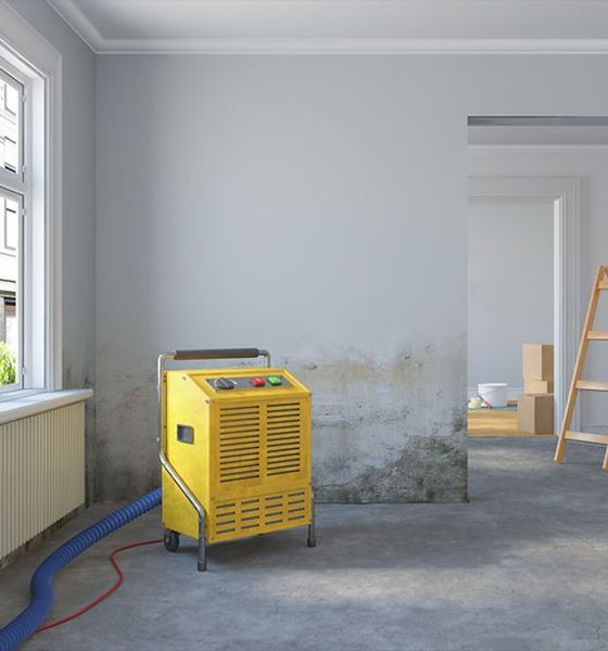 Dehumidification machine is sitting in a room next to a window.