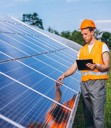 Solar panel inspector in orange safety gear examining solar panels.