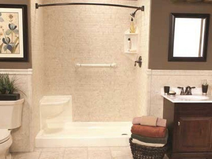 A bathroom with a walk in shower , toilet , sink and mirror.