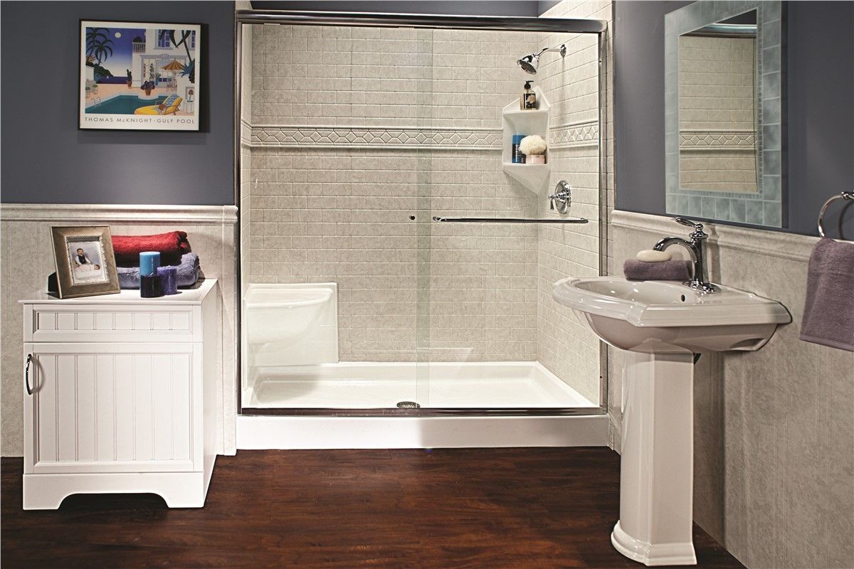 A bathroom with a sliding glass shower door , sink , and bathtub.