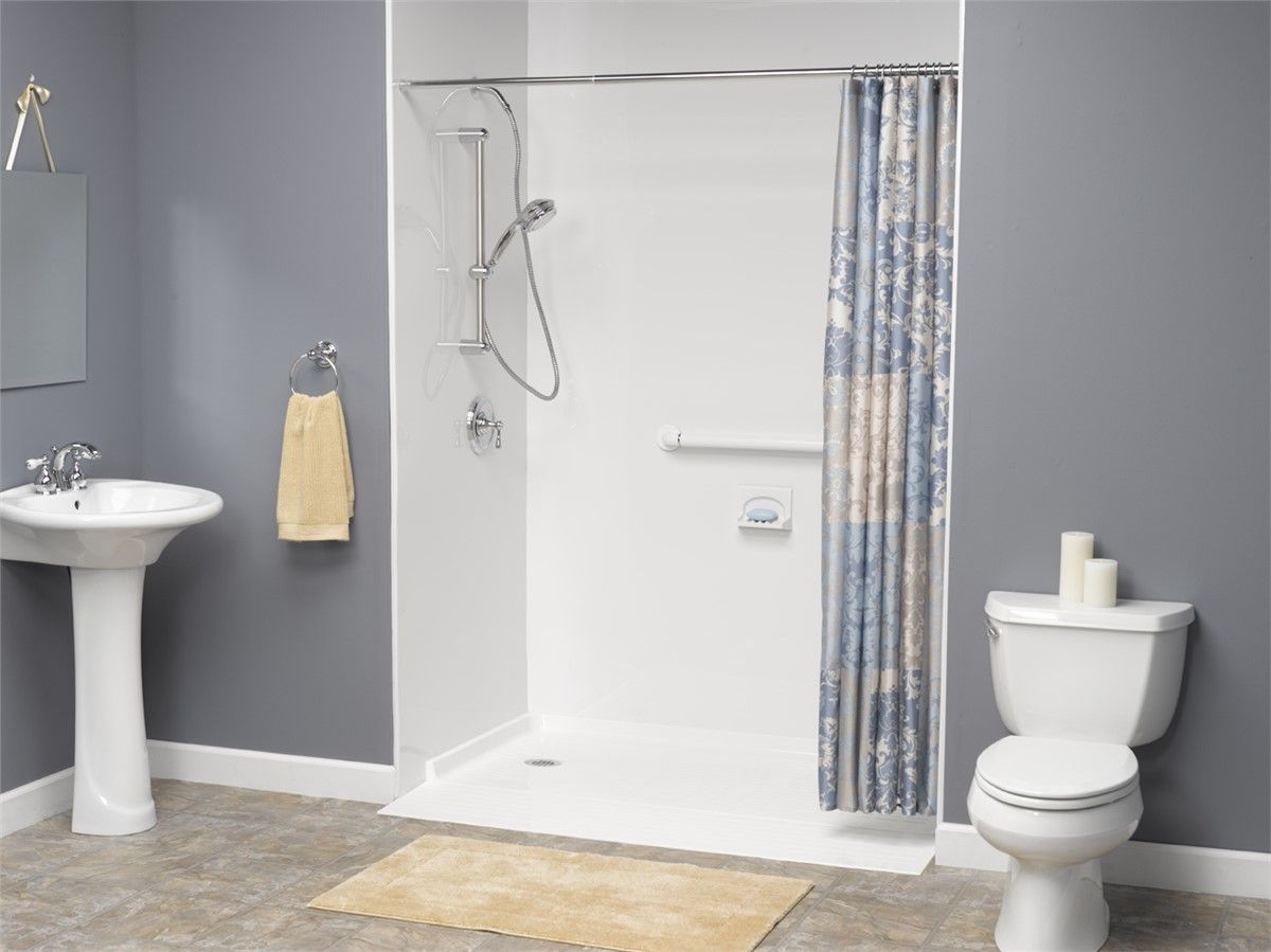A bathroom with a walk in shower , toilet , sink and mirror.