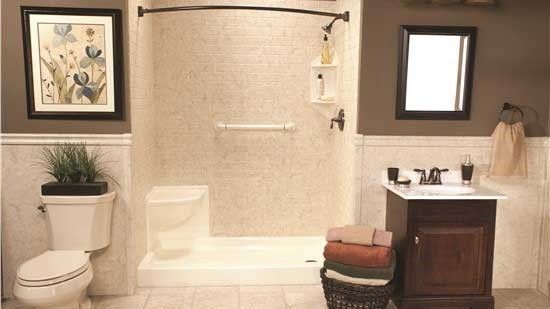 A bathroom with a toilet , sink and shower.
