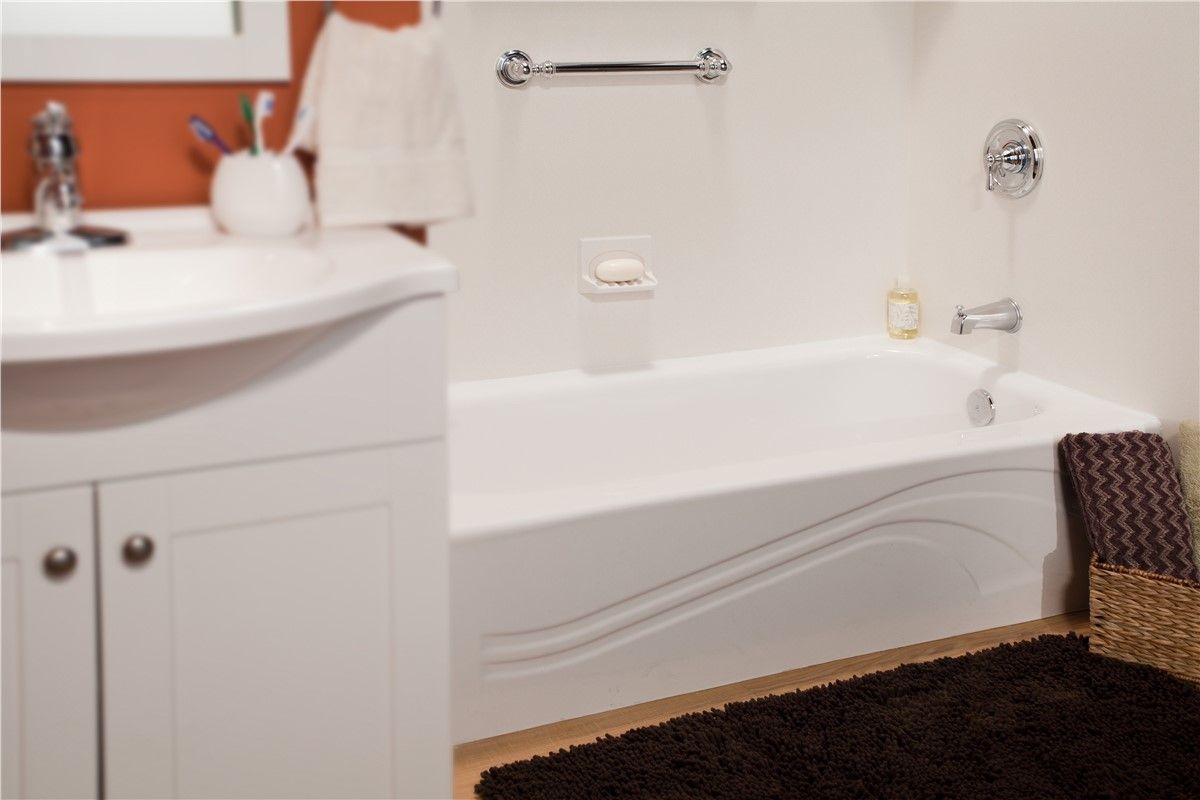 A bathroom with a bathtub a sink and a rug