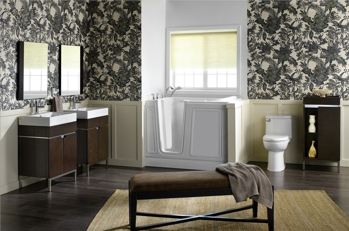 A bathroom with two sinks , a toilet , and a bench.