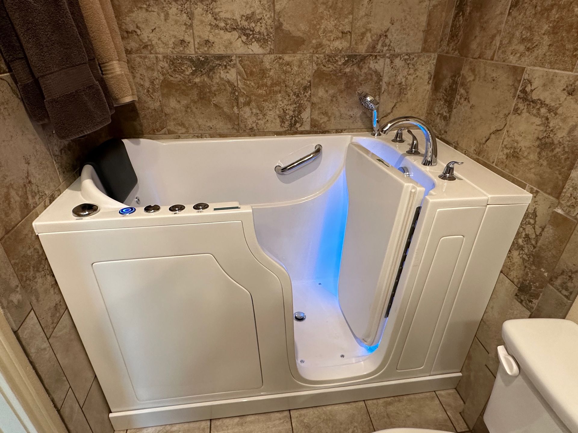 A walk in tub is in a bathroom next to a toilet.