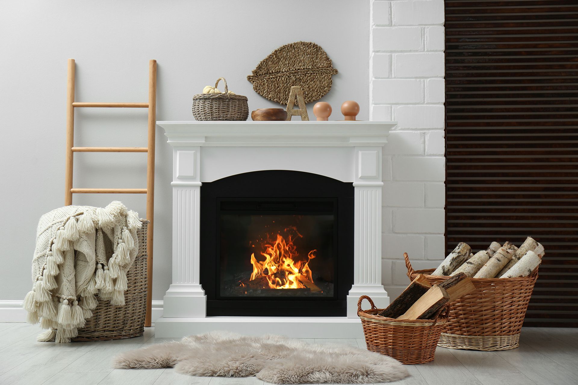 A living room with a fireplace and a basket of logs.