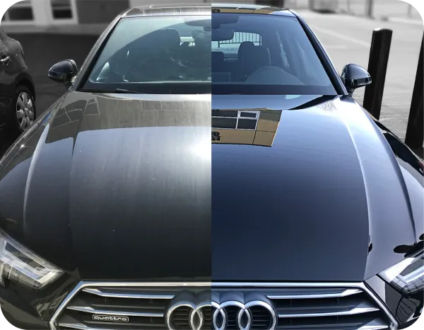 Black Audi RS4 Avant parked outside, next to a green and white van, under an overcast sky.