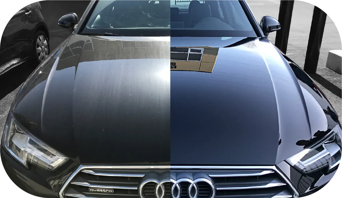 Black Audi RS4, silver wheels, parked near a green and white van, outdoors.