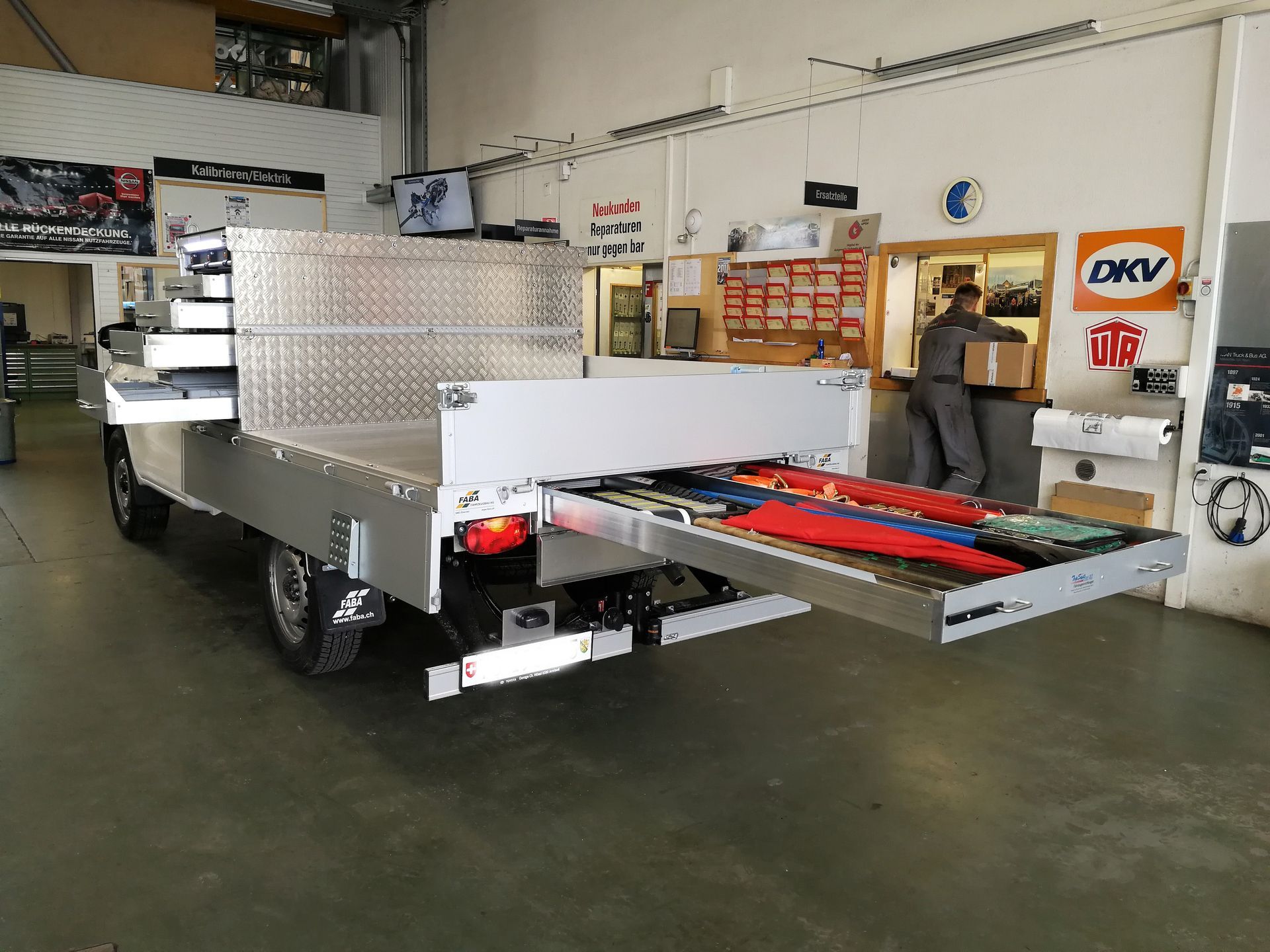In einer Garage steht ein LKW mit einer Schublade darunter.