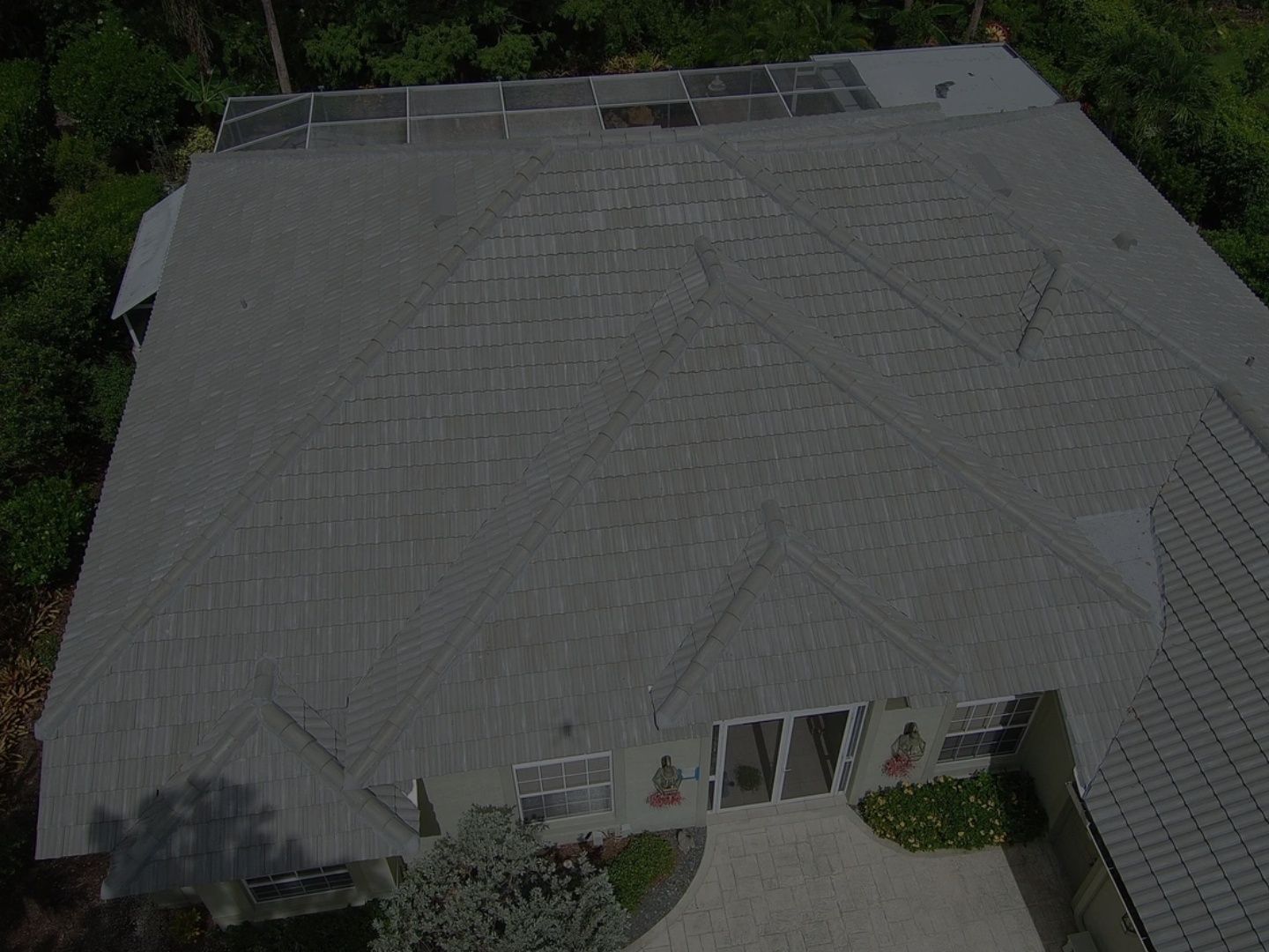Aerial view of a house with a gray shingle roof and a small front entrance area