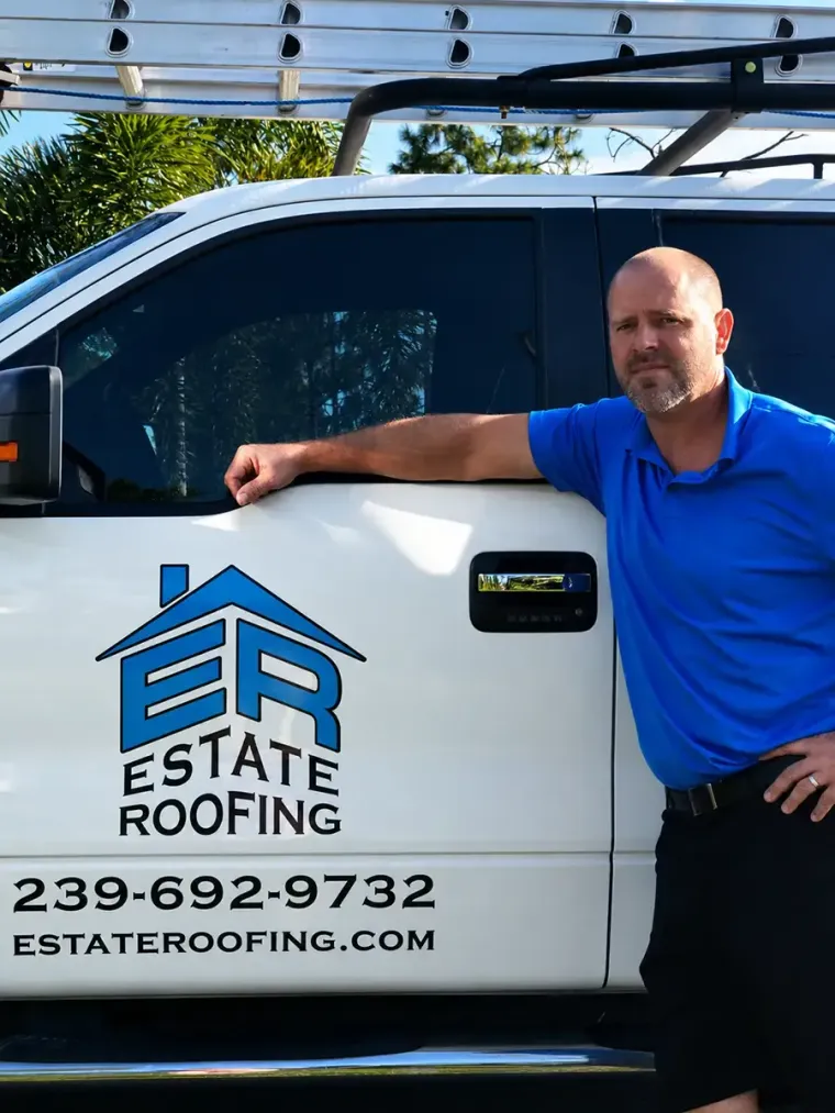 Estate Roofing truck with company logo and phone number, man in blue shirt leaning on the vehicle
