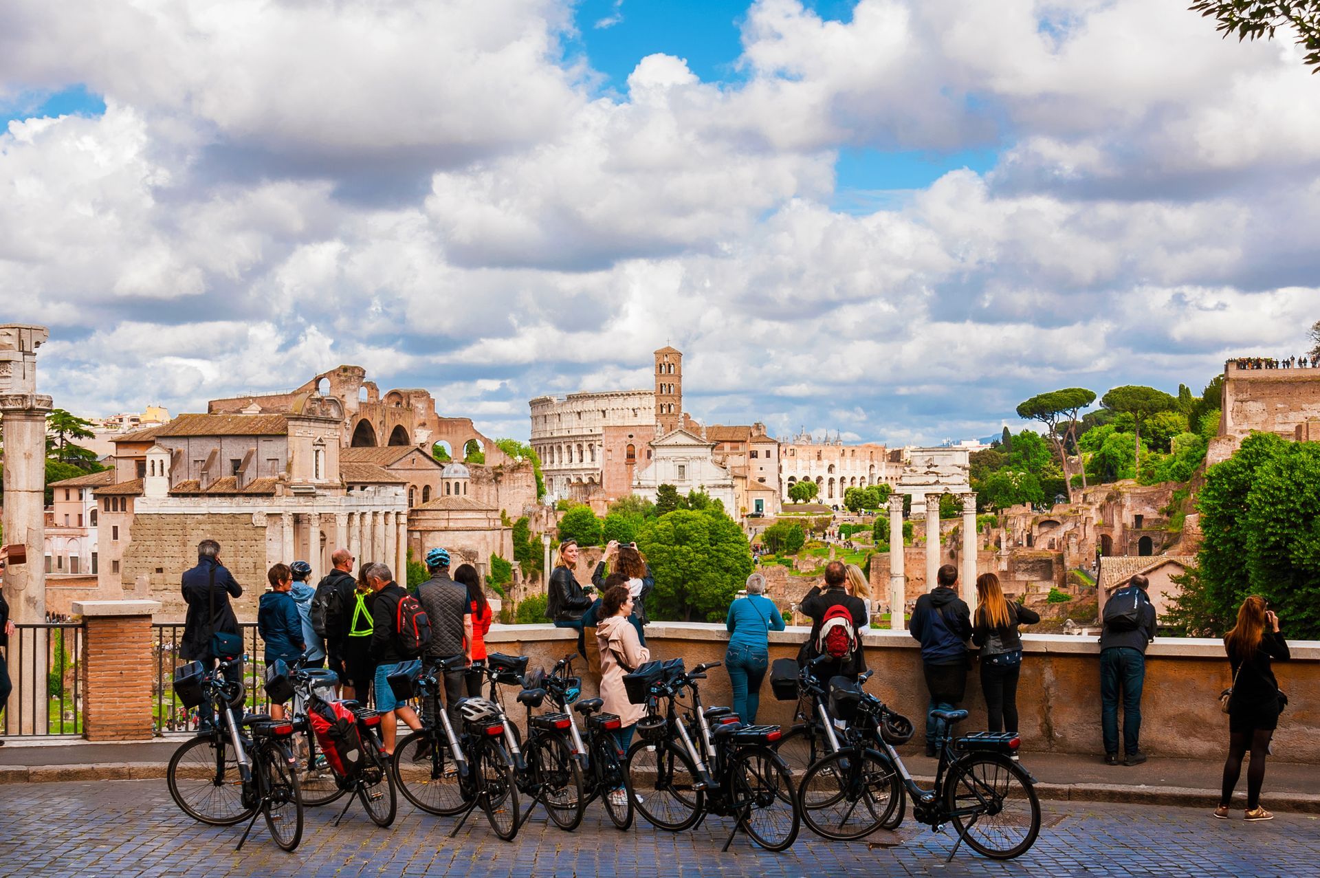 Cyclists on a bridge overlooking historic buildings and cloudy sky in a cityscape