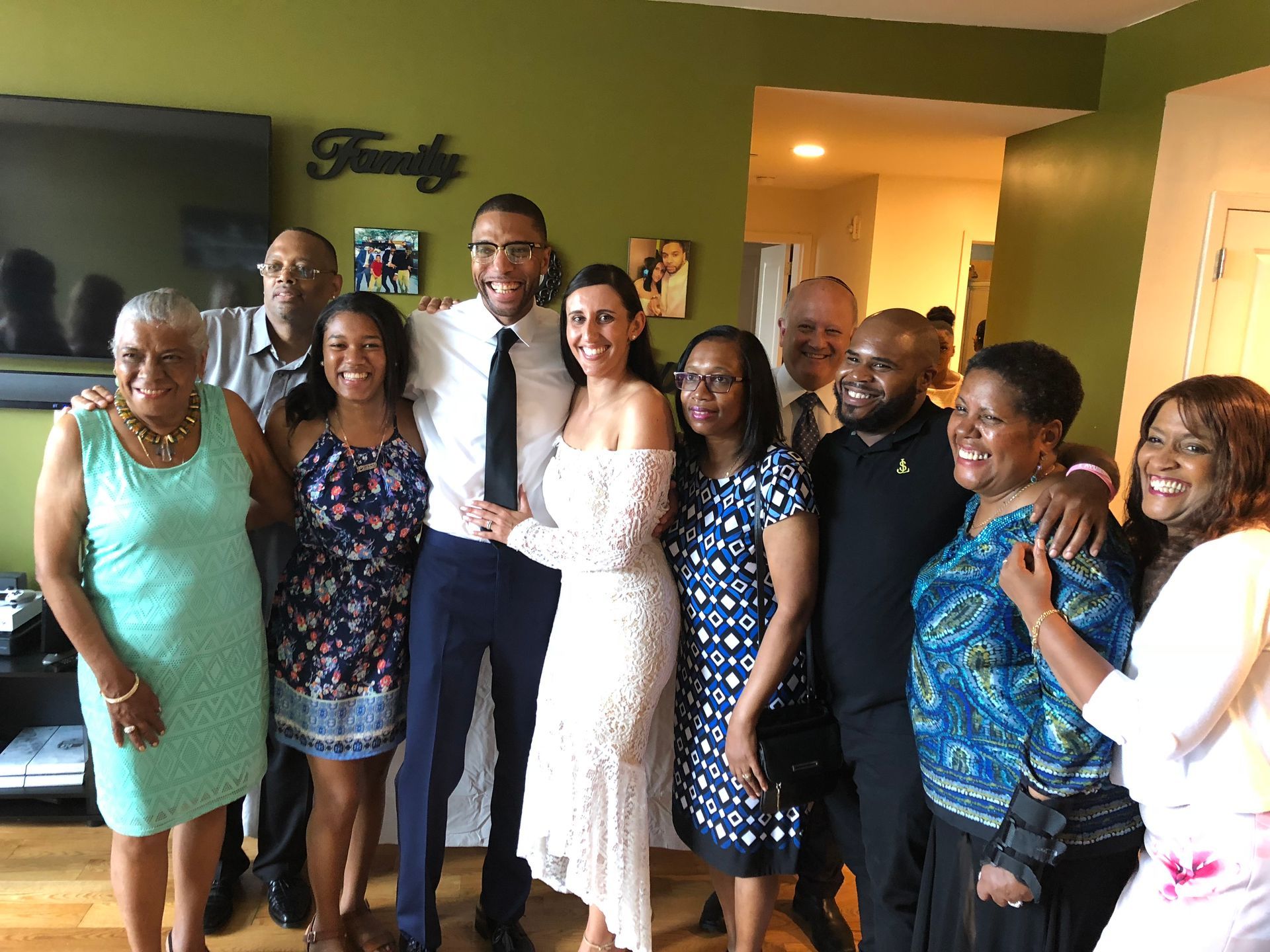 Group of people standing together indoors, smiling and posing for a photo at a celebration.