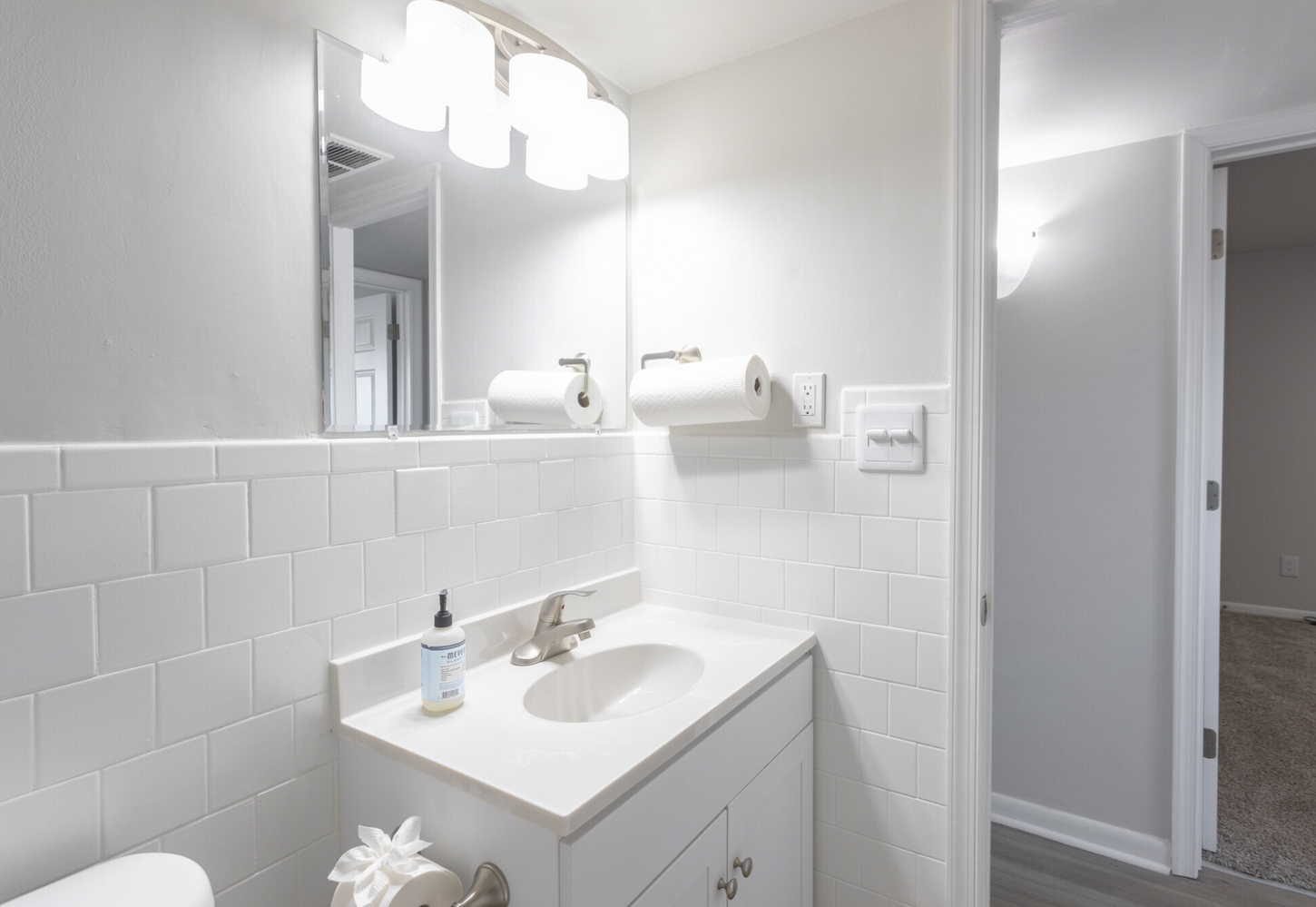 A bathroom with a sink , toilet and mirror.