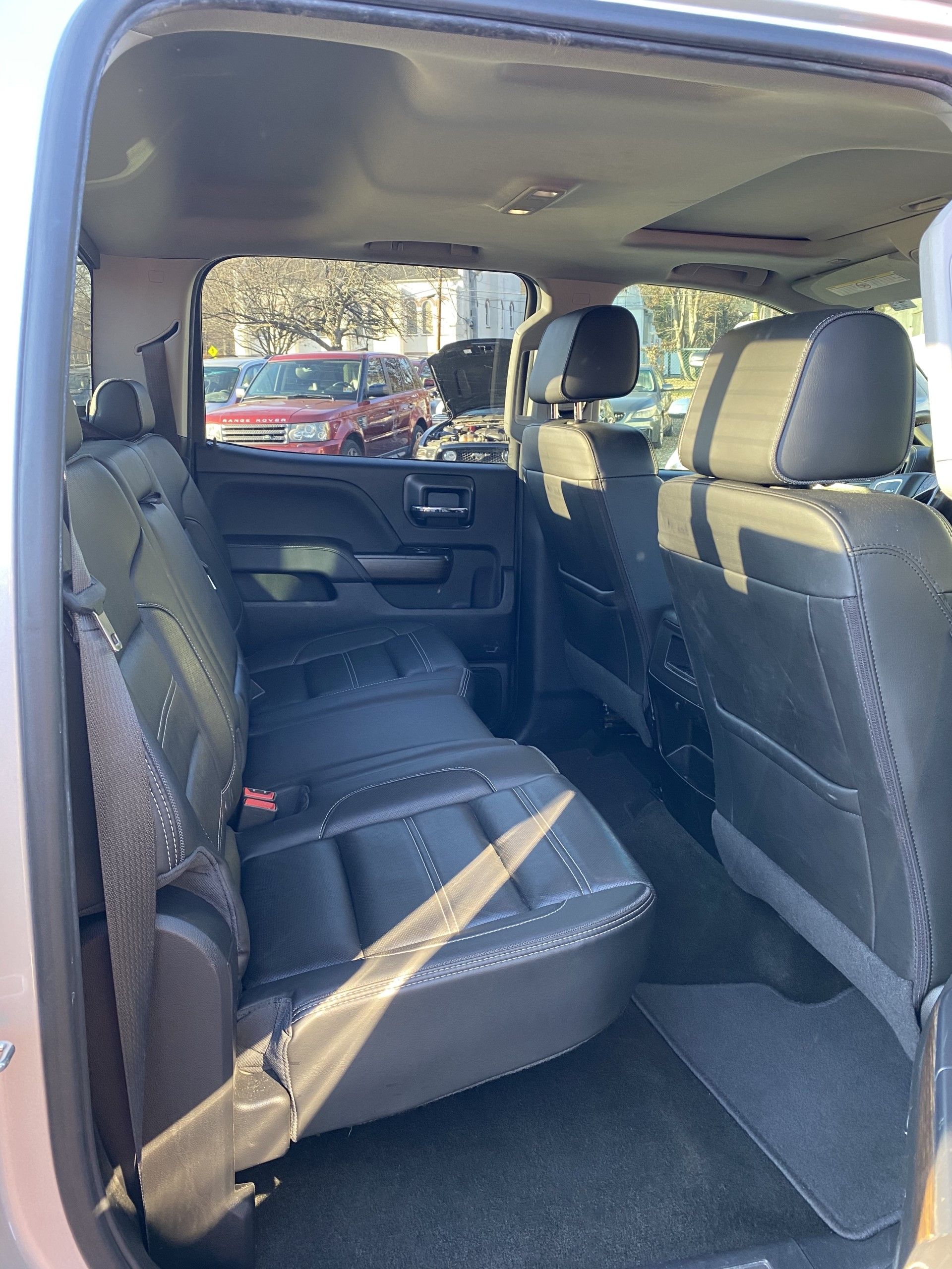 The back seat of a silver truck with black seats. | InTown Auto Care