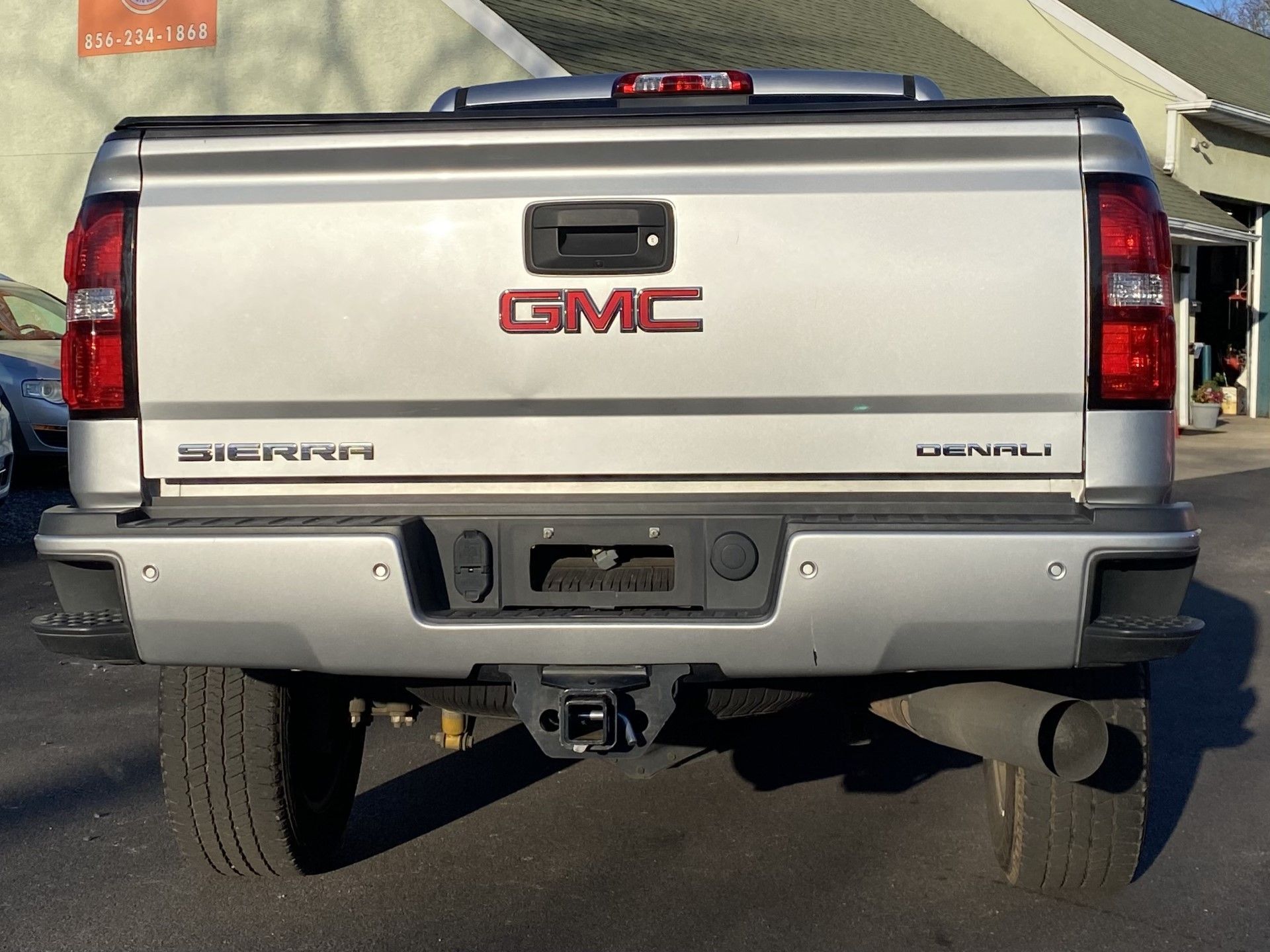 A silver gmc truck is parked in front of a building | InTown Auto Care