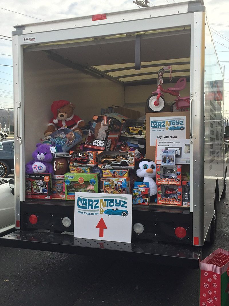 A truck filled with lots of toys and a sign that says crazy news | InTown Auto Care