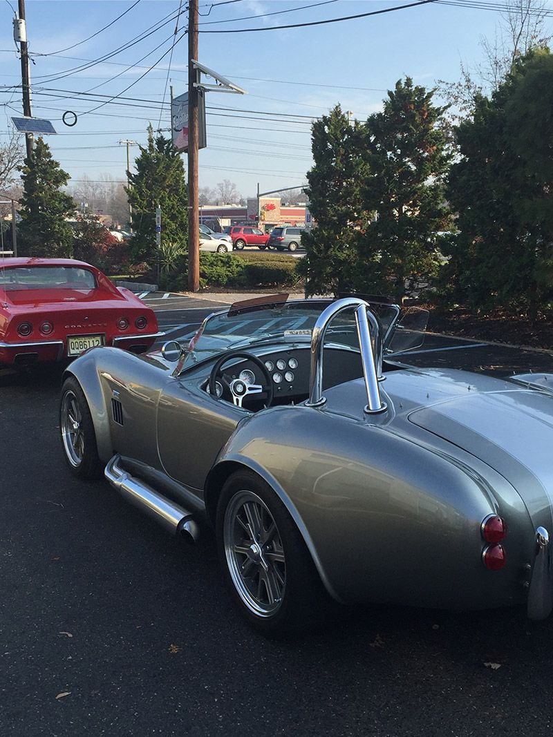 A Silver Vintage Sports Car is Parked Next to a Red Corvette in Moorestown, NJ - InTown Auto Care