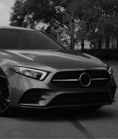 A black and white photo of a mercedes benz a class parked in a parking lot. | InTown Auto Care