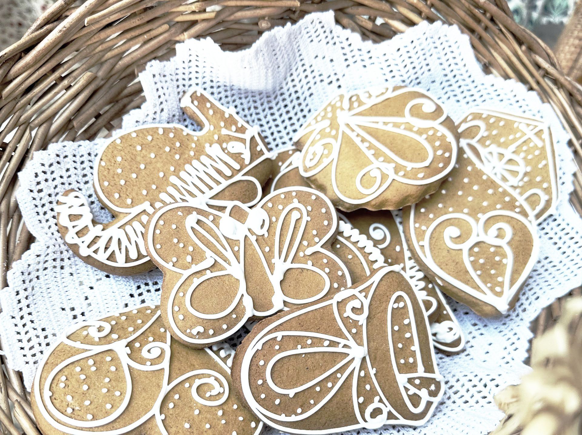 A basket filled with gingerbread cookies on a white lace cloth.