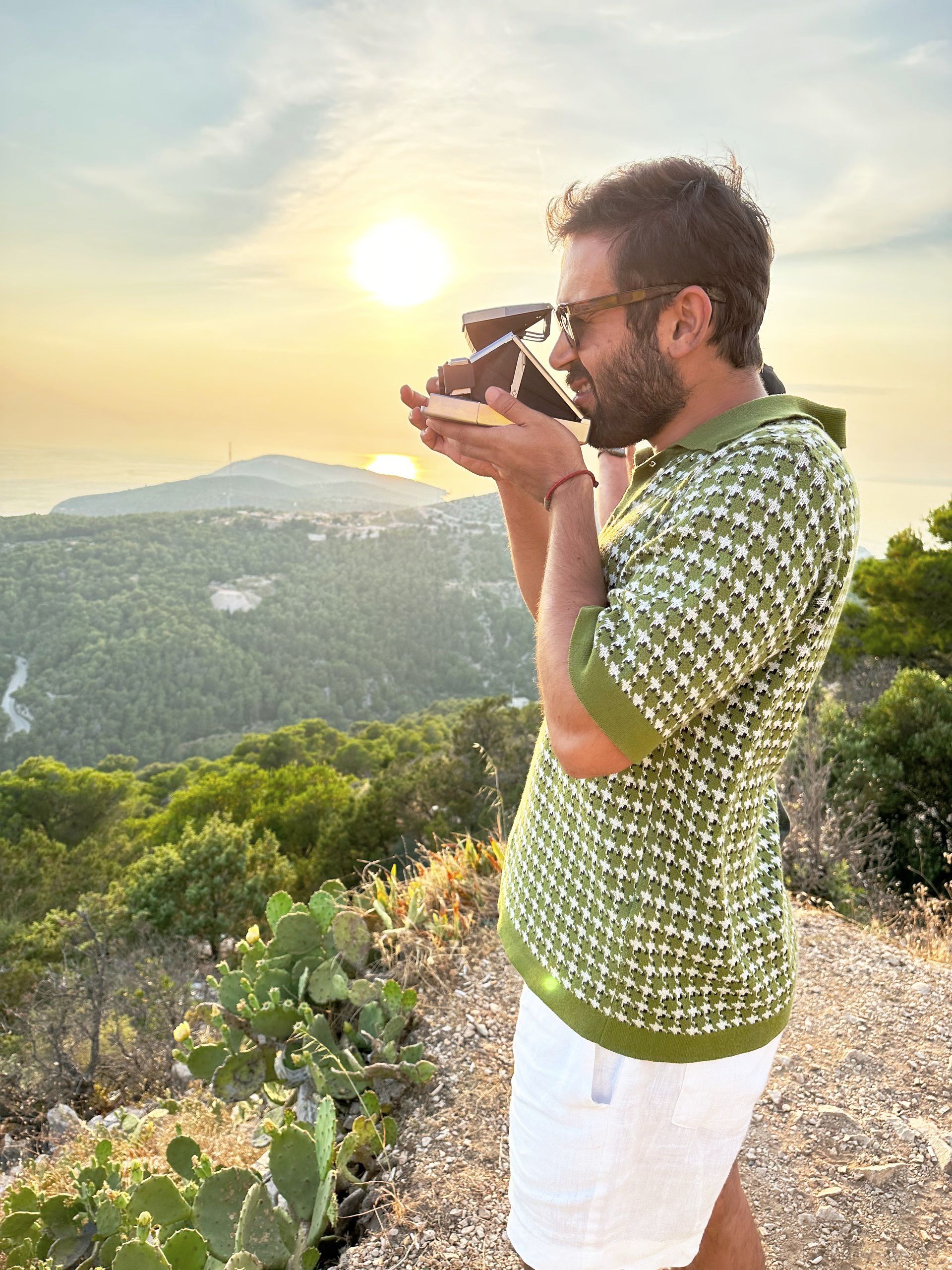 A man taking a photo from the hill on an old camera