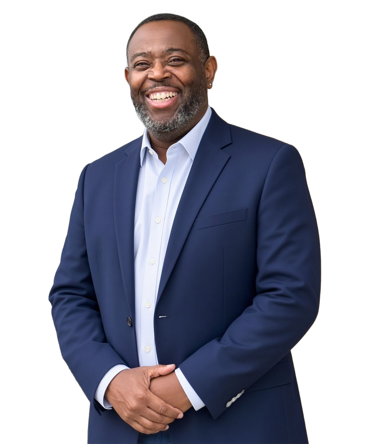 Man in a navy suit smiling beside a stone wall outdoors