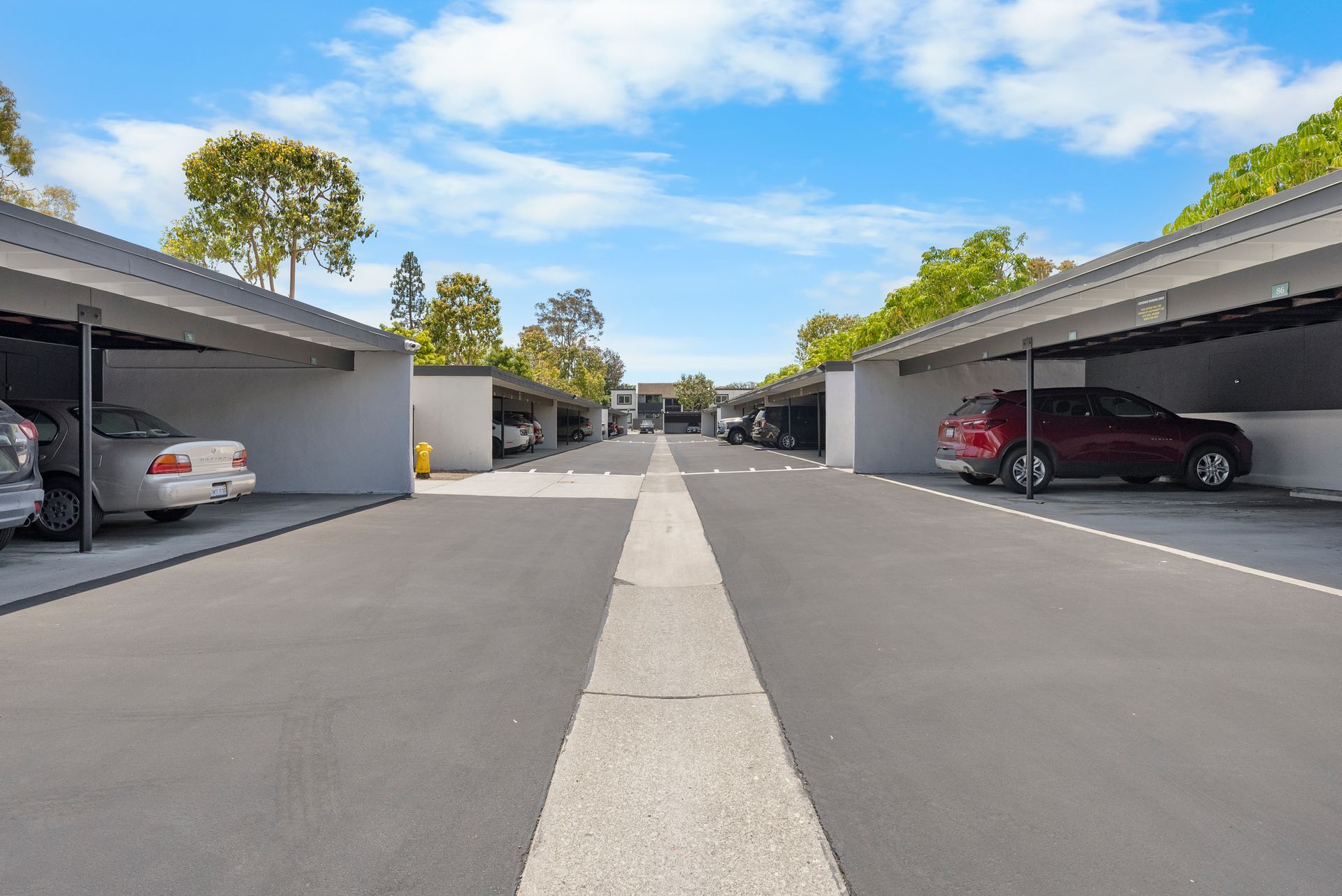 A row of cars are parked in a parking lot.